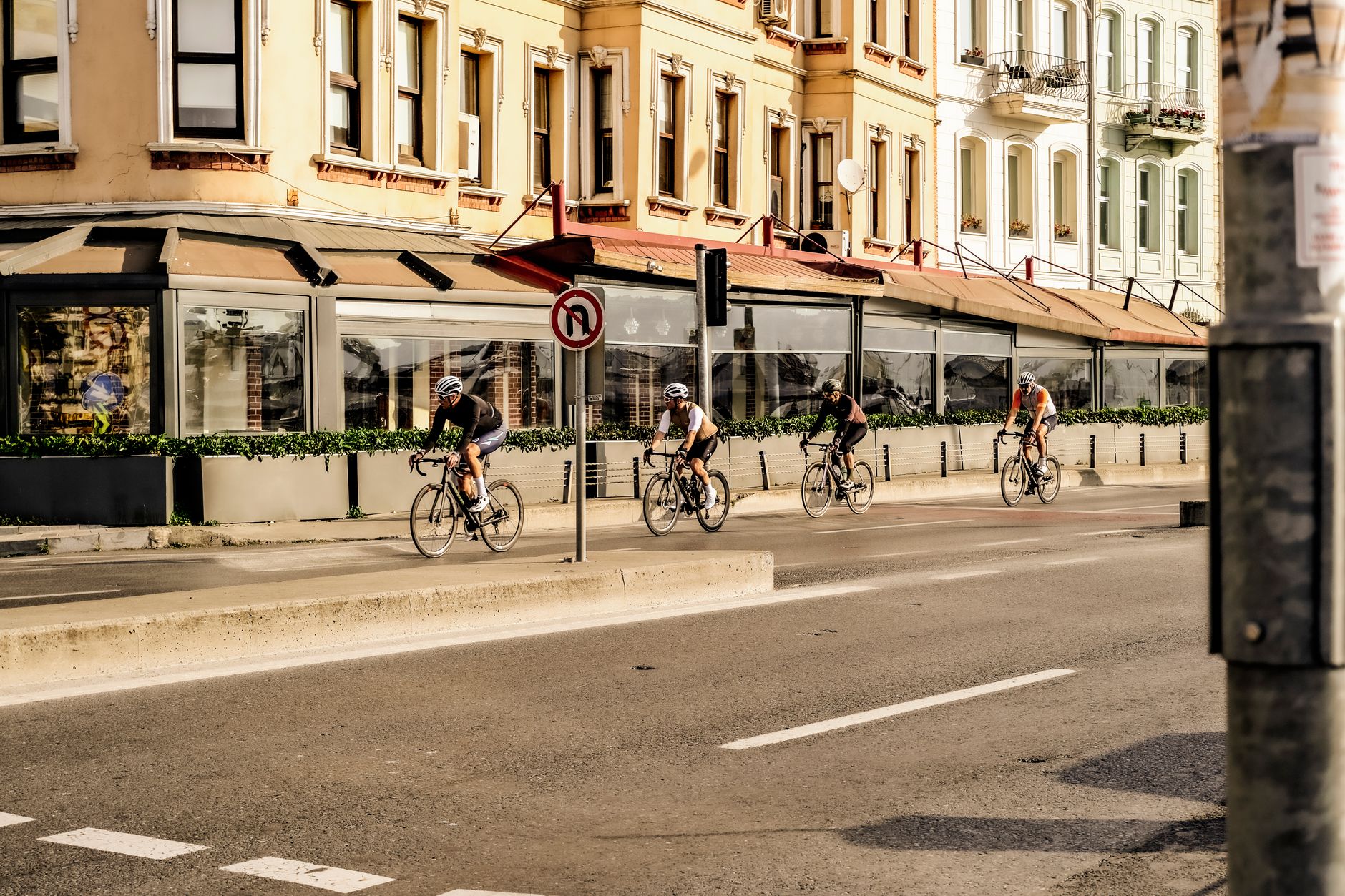 Cyclists riding through a city street in soft evening light