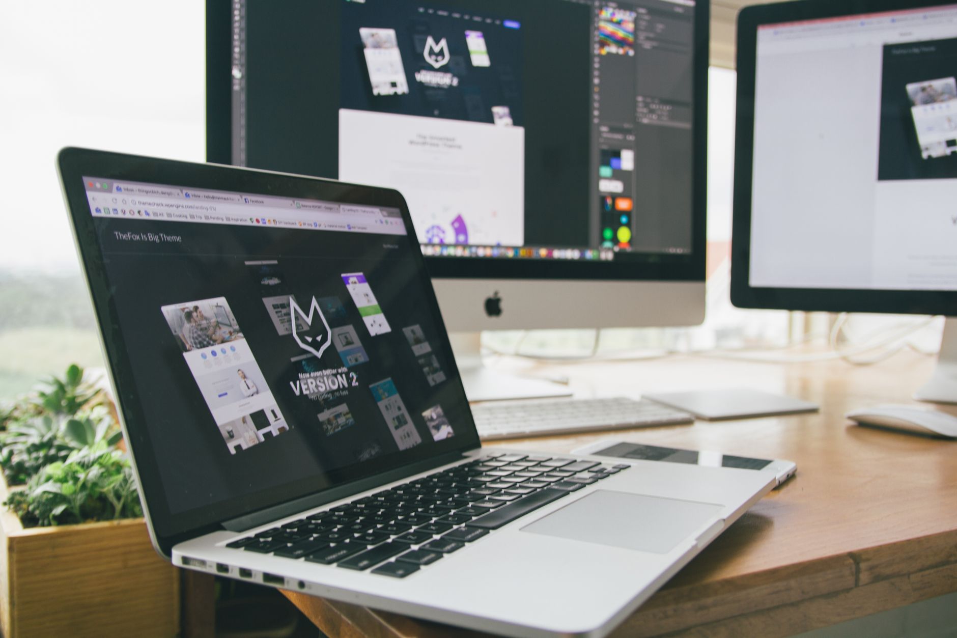 Designer's laptop showing a website layout on a tidy workspace