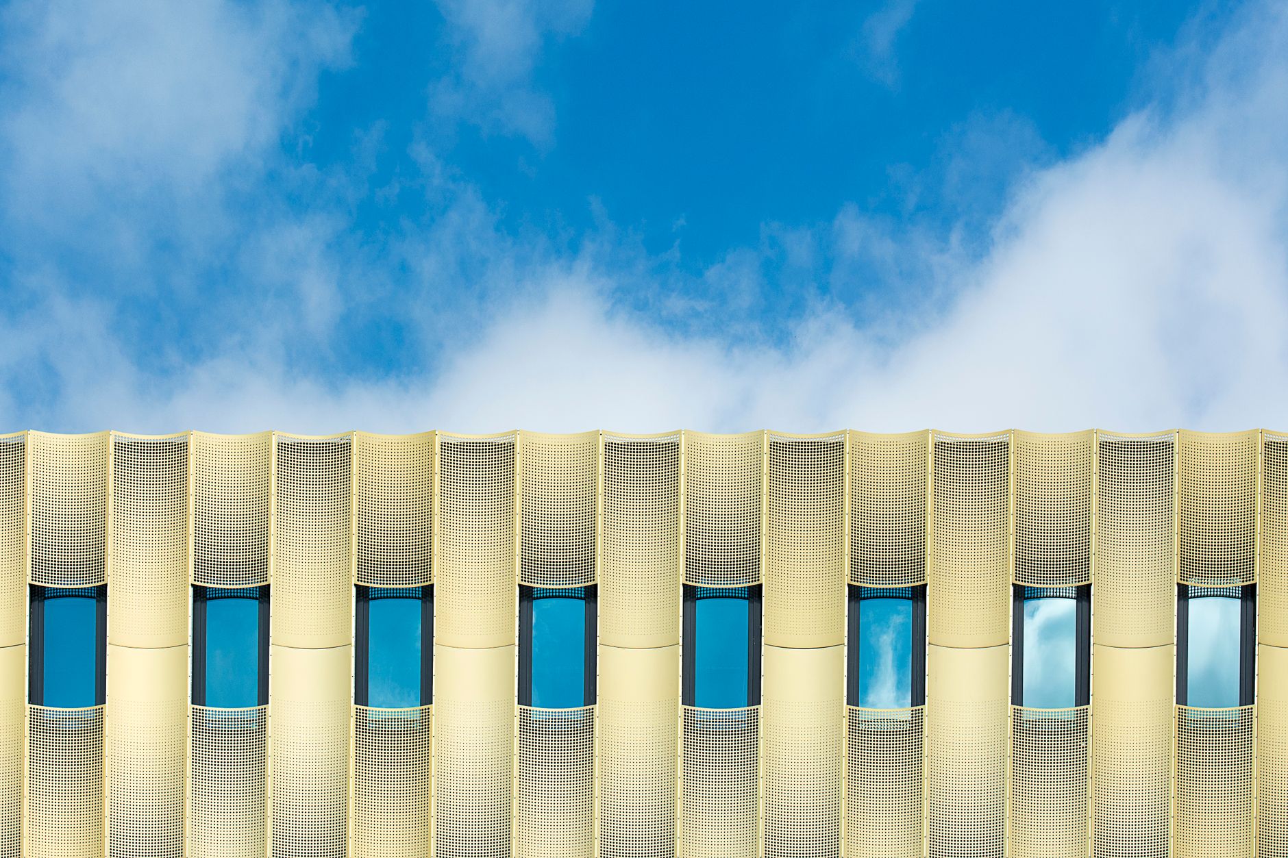 Modern building facade with strong geometric lines against the sky