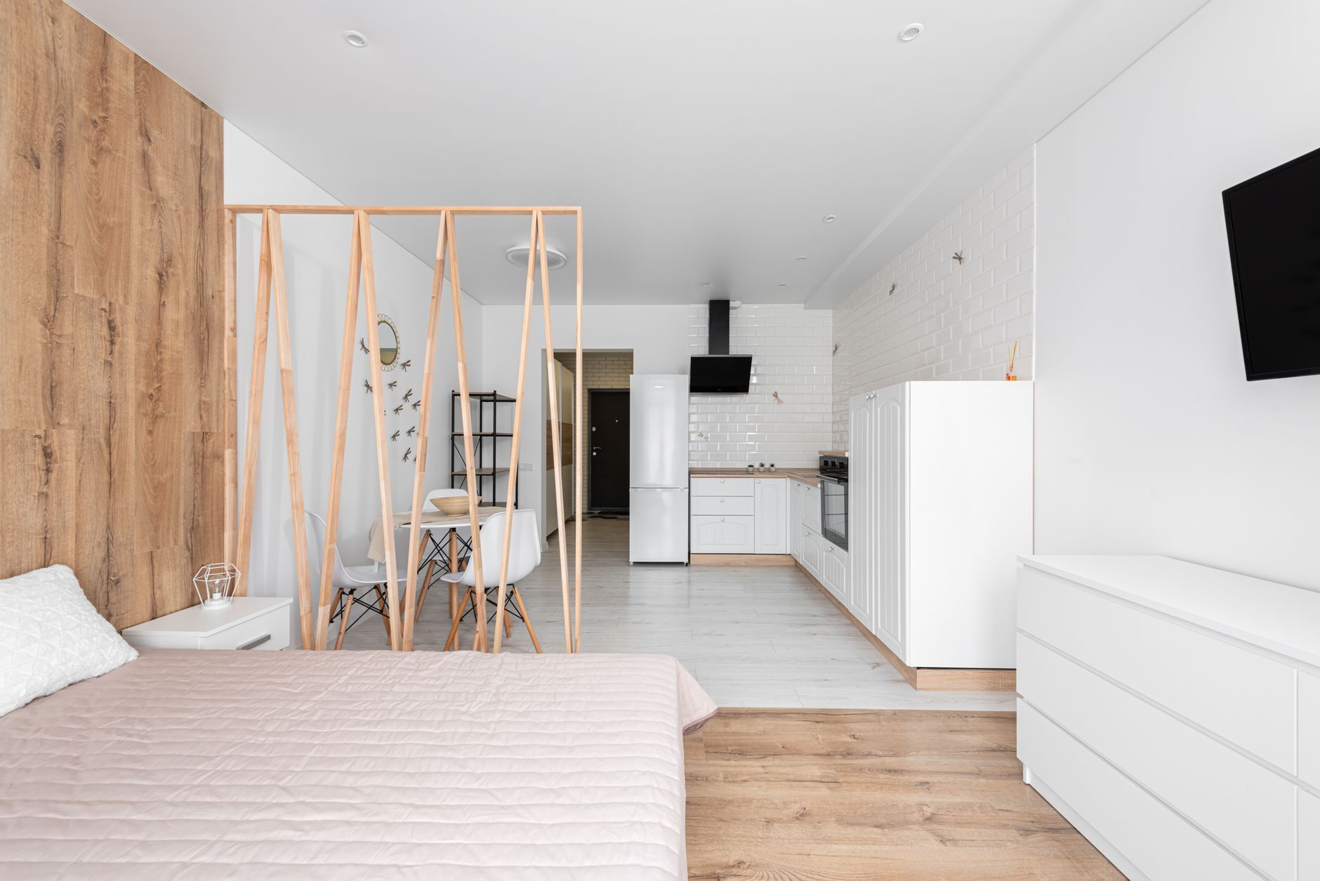 Open-plan design studio with long wooden tables, plants and large windows